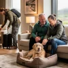 A couple pets a golden retriever in a dog bed while other guests arrive at a modern hotel room.